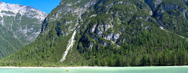 Lago di Landro (or called Durrensee) extra wide panorama with boat in Alps, Dolomites, Europe