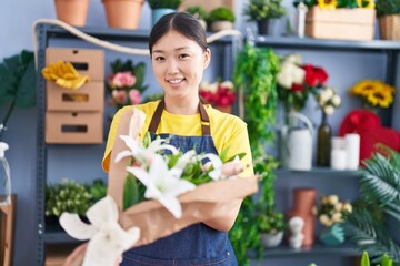 Chinese woman florist holding bouquet of flowers at florist shop