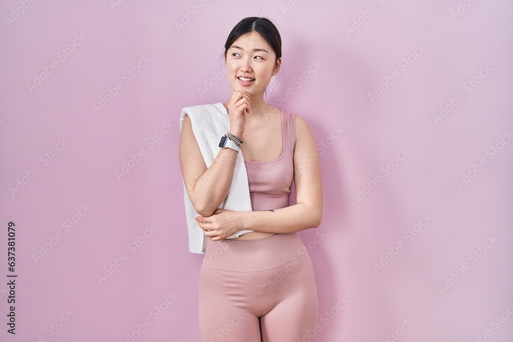 Canvas Prints Chinese young woman wearing sportswear and towel with hand on chin thinking about question, pensive expression. smiling and thoughtful face. doubt concept.