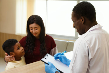 Fototapeta premium mother and her boy talk to african american pediatrician doctor for illness treatment in hospital. healthcare concept.