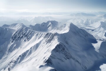Fototapeta premium A majestic snow-covered mountain range shrouded in ethereal clouds