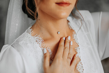 Morning preparation of the bride. Necklace on the neck. A pendant on a woman's neck. The girl...