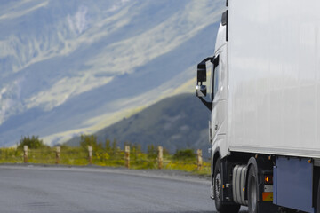semi truck driving through mountain road pass