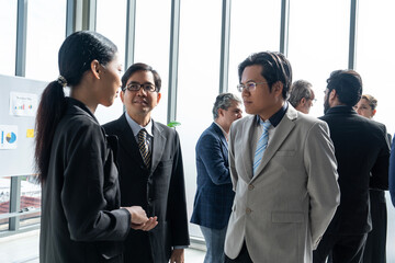 Group of multinational executives, men and women in suits, standing and talking, share ideas, sharing business ideas in new employee training meeting