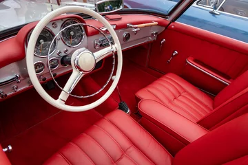 Fototapeten Interior of a classic vintage car, red leather. © dechevm