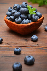 blueberries are poured out on a wooden table from a bowl