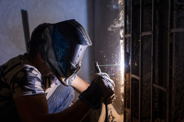 a man welding the gate in a side