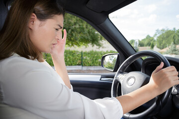 woman with headache in a car