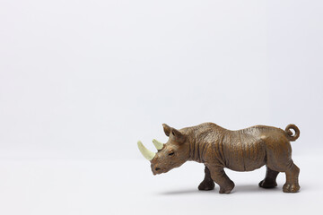 a plastic toy rhinoceros on a white background