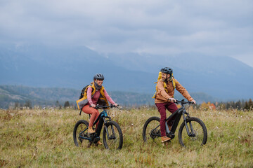 Happy couple at bicycles, in the middle of autumn nature. Concept of a healthy lifestyle.