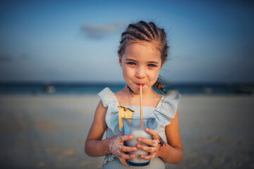 Portrait of a little adorable girl on a sandy beach by the sea.