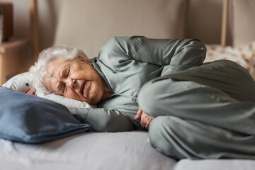 Senior woman sleeping in her bed alone.