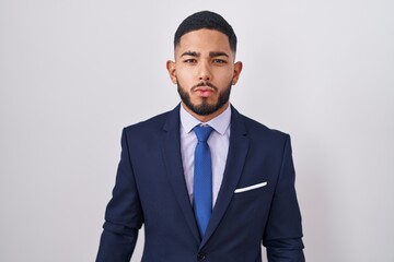 Young hispanic man wearing business suit and tie looking at the camera blowing a kiss on air being lovely and sexy. love expression.