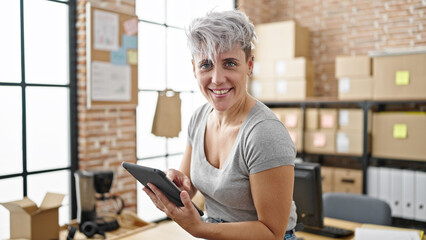Young woman ecommerce business worker using touchpad smiling at office