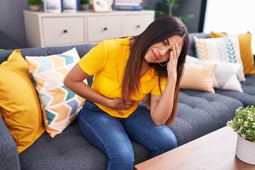 Young beautiful arab woman suffering for head and stomach ache at home