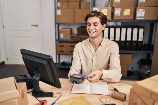 Young caucasian man ecommerce business worker using data phone and credit card at office