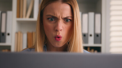 Close up angry upset Caucasian woman user using laptop in home office frustrated mad confused...
