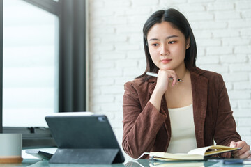 A young female administrative assistant making notes of working planning organizing information in...