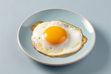 a fried egg on a plate on a blue table