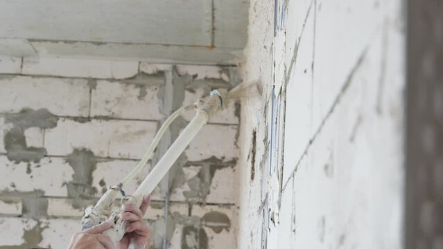 Machine plastering. Plastering pump for automatically spraying gypsum plaster application.