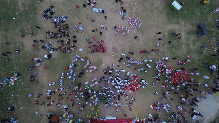 Aerial view of Indonesian flag lowering ceremony witnessed by villagers. Indonesia Independence Day
