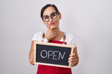 Middle age brunette woman holding banner with open text serious face thinking about question with...