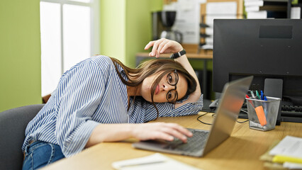 Young beautiful hispanic woman business worker looking watch leaning on table tired at office