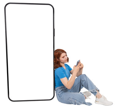 Big huge mobile phone, full body young red bob hair caucasian woman sit near big huge mobile phone. Smartphone mock up with empty blank white screen. Using cell phone. Isolated transparent png image.