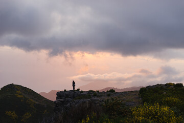 Travelling and exploring Madeira island landscapes and travel destinations. Young female tourist enjoying the sunrise and outdoor spectacular scenery. Summer tourism by Atlantic  ocean and mountains.