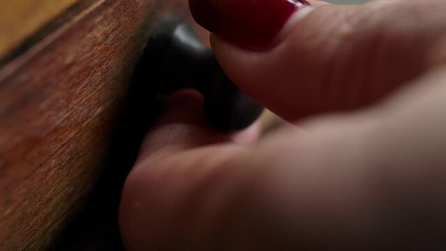 Hand opens drawer of vintage coffee grinder