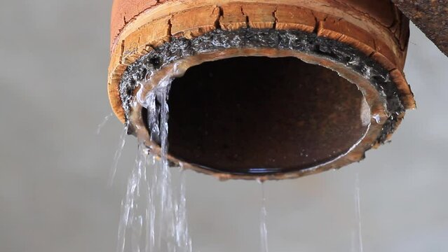 closeup of broken industrial drain / water pipe dripping water