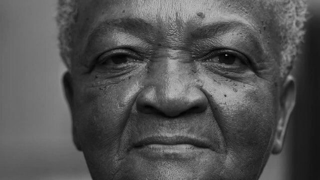 African American senior woman close-up face in dramatic monochromatic black and white. A black Brazilian elderly lady looking at camera