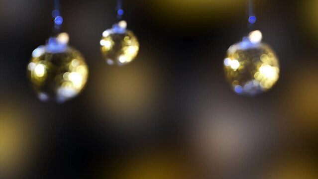 three blurred glittering christmas tree balls hanging on abstract background with copy space, bright bokeh light decoration for xmas celebration or happy new years 