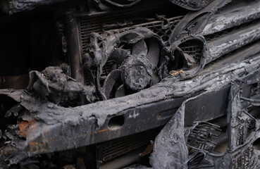 Burnt engine compartment of modern car. Burnt out car and faulty electrical wiring in car