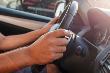 Hands of car driver on steering wheel. Road danger concept