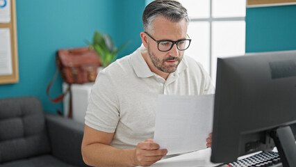 Grey-haired man business worker wearing glasses working at the office