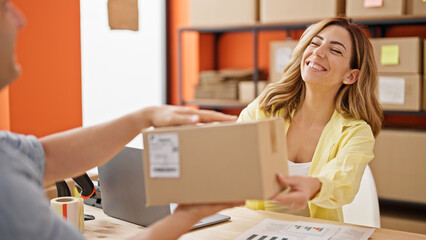 Man and woman ecommerce business worker giving package to client at office