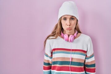 Young blonde woman standing over pink background depressed and worry for distress, crying angry and...