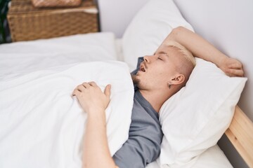 Obraz na płótnie Canvas Young caucasian man lying on bed sleeping at bedroom