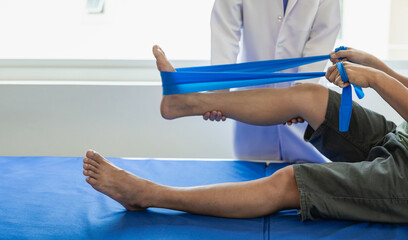 The physiotherapist doctor works to monitor the treatment of the patient's injured knees and legs,...