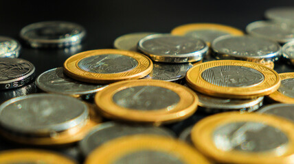 Moedas brasileiras de um real e de cinquenta centavos em um fundo neutro