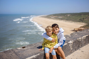 Family with children, visiting the beach with the biggest waves in the world in Nazare, Portugal