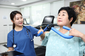 병원의 물리치료실에서 재활치료사가 환자의 회복을 돕는 모습