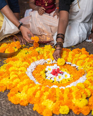 Happy Onam concept image, Indian family making Onam Pookalam with flowers, South Indian tadeonal festival background