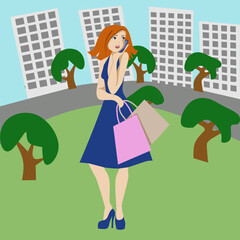 Girl in the city. A girl with packages in her hands is talking on the phone in a green area among city buildings.
