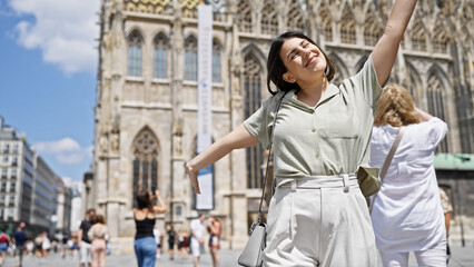Young beautiful hispanic woman with open arms at St. Stephen's Cathedral