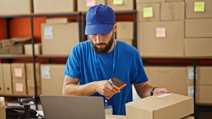 Young hispanic man ecommerce worker scanning packages at office