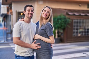 Man and woman couple hugging each other expecting baby at street