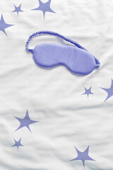 Top view blue sleep mask and stars on white cloth background. Eye cover mask for best sleep....