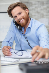 happy young male customer support executive working in office